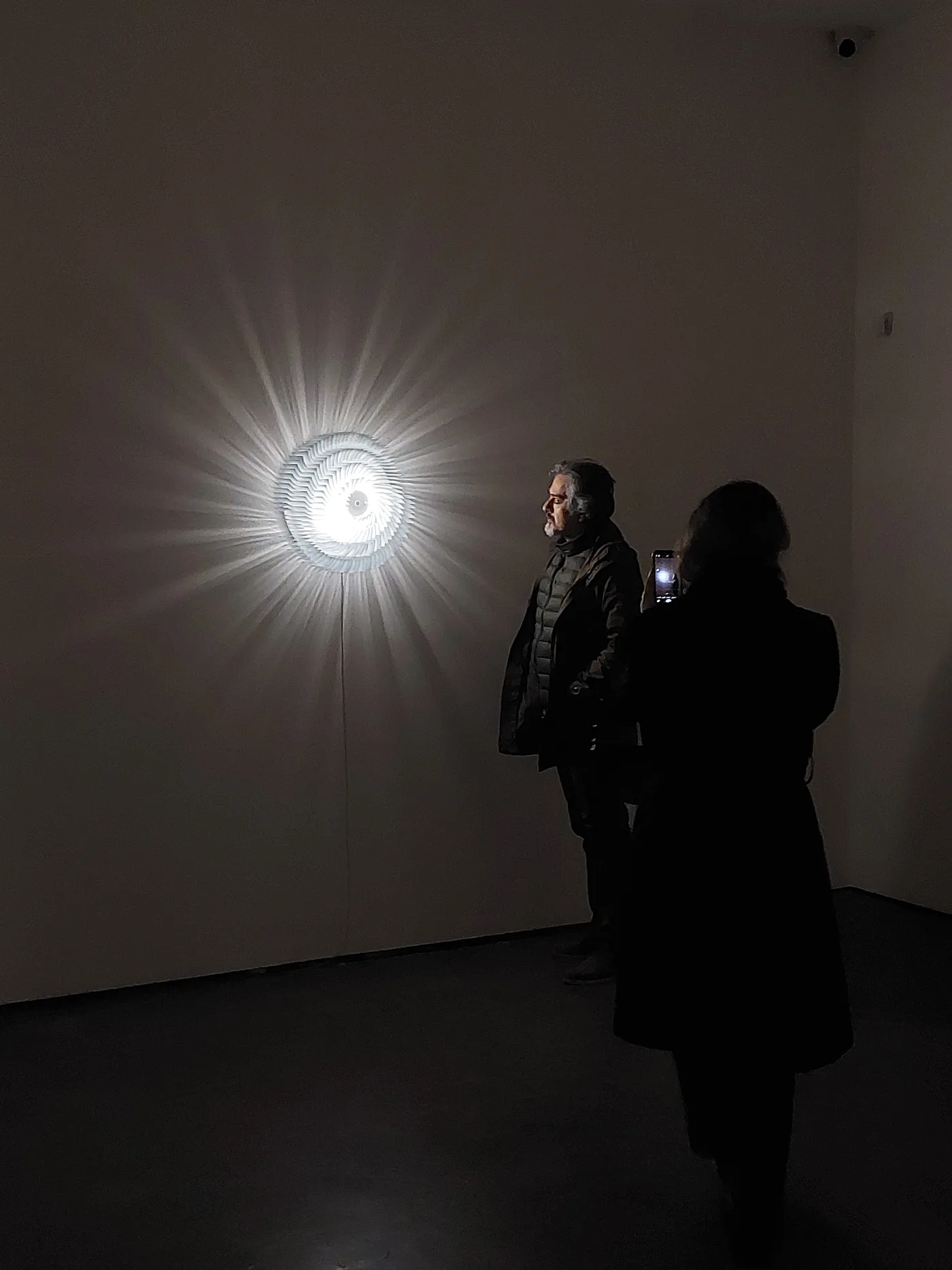 A visitor photographing the radial light work