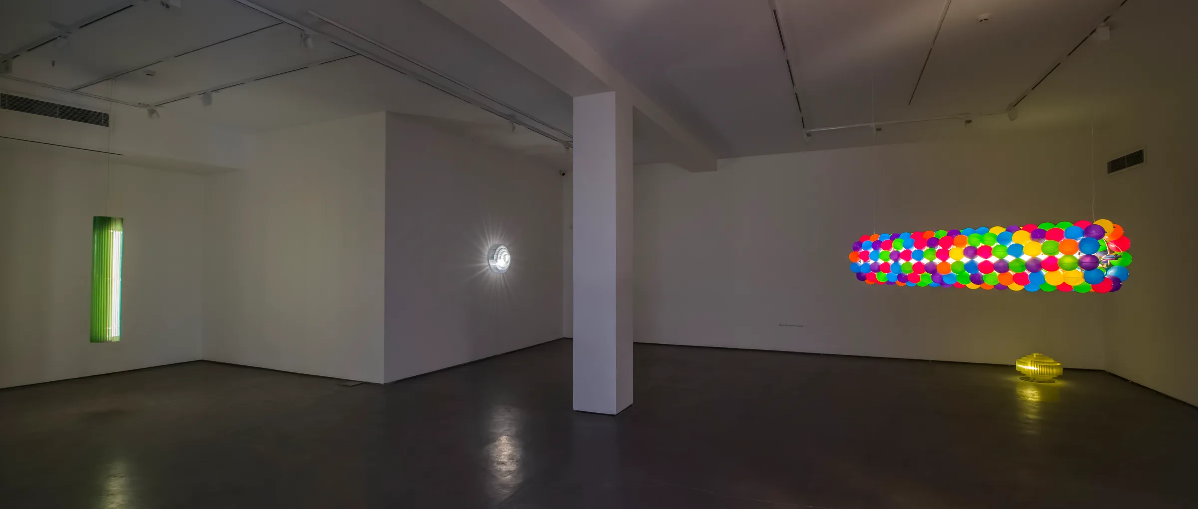 The darkened gallery at IranShahr — Keker, a radial light and Tooper suspended in space