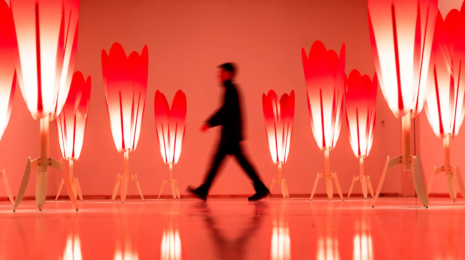 The Crimson Procession — a field of glowing red tulip lamps surrounding a lone visitor