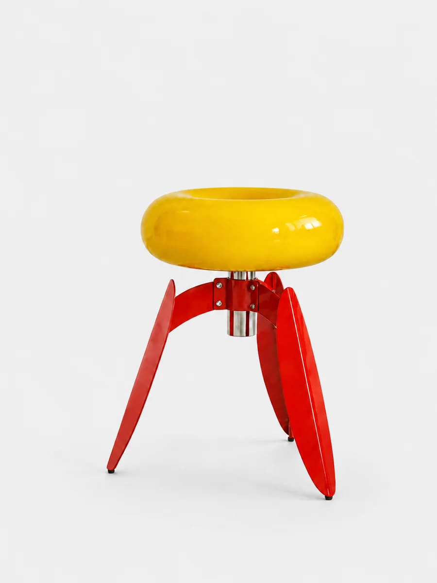 Dot Nut stool — a glossy yellow ring seat on red leaf-bent legs