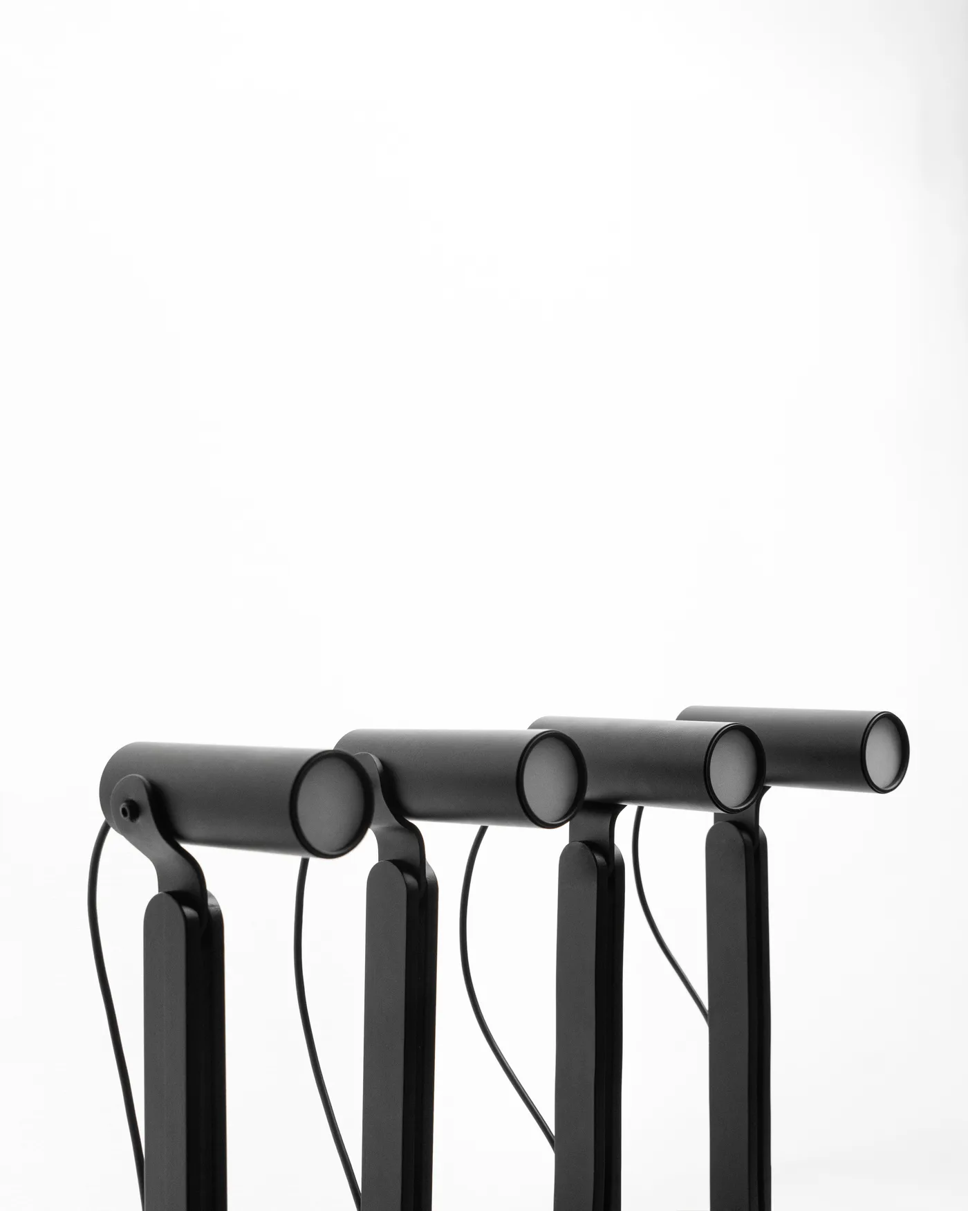 Four black Arte lamps lined up, heads levelled together