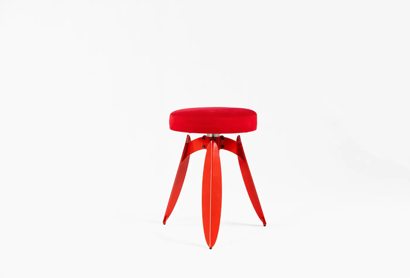 Dot stool in red — three leaf-bent legs around a central point