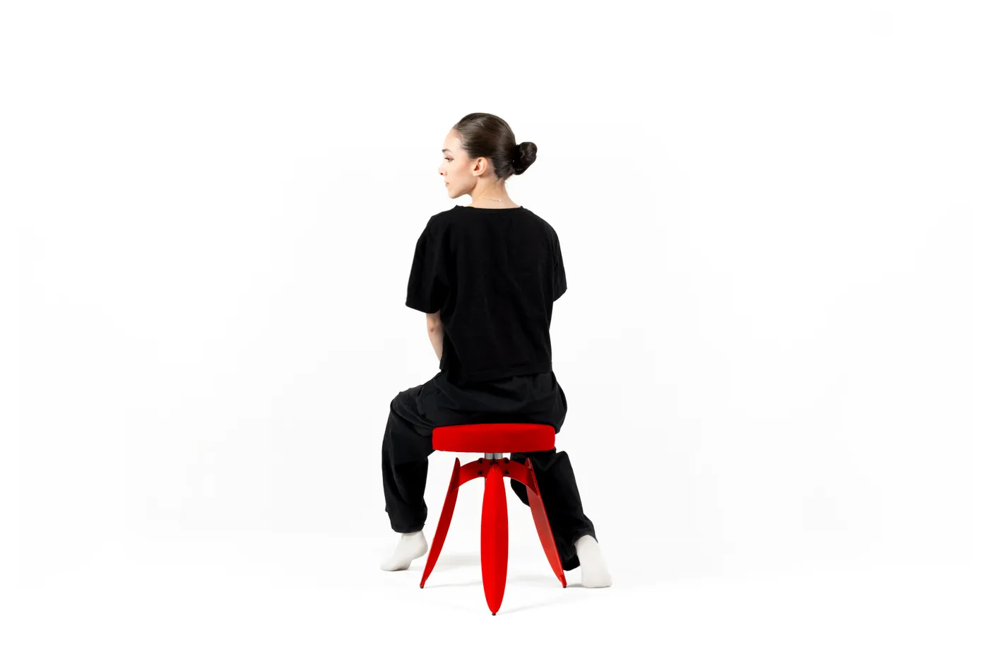 Seated on the red Dot stool, seen from behind