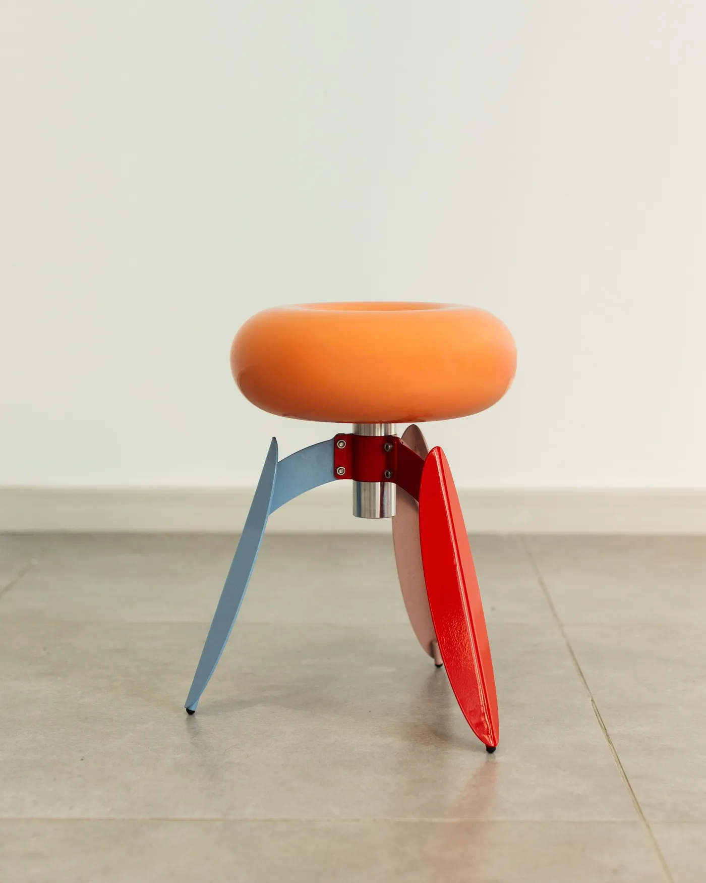 Dot Nut stool — an orange fiberglass ring on red and blue steel legs