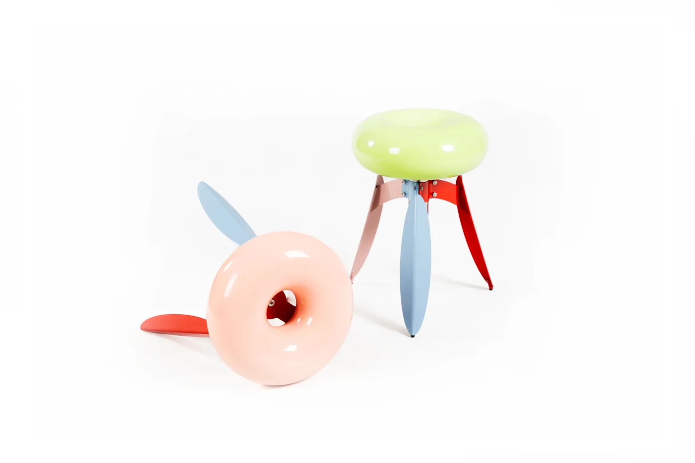 Two Dot Nut stools side by side — green and orange seats
