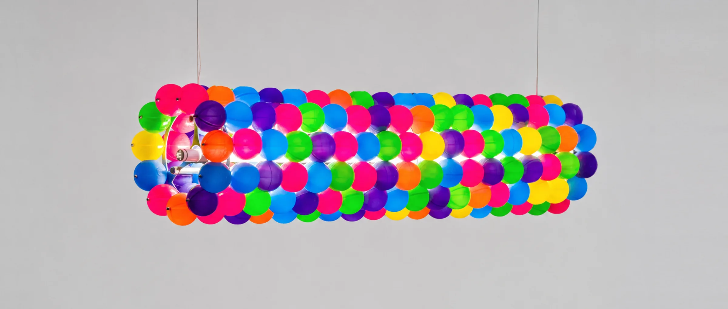 Tooper's cylinder of multicoloured play balls, suspended and glowing in the dark