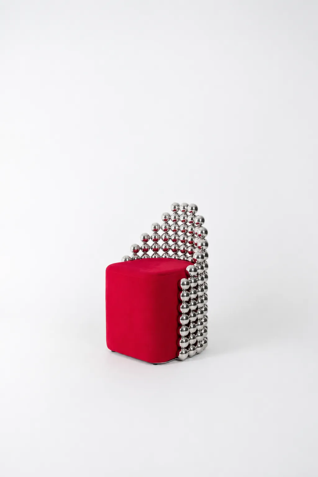 Wishes chair — a red seat held by a back of chrome spheres