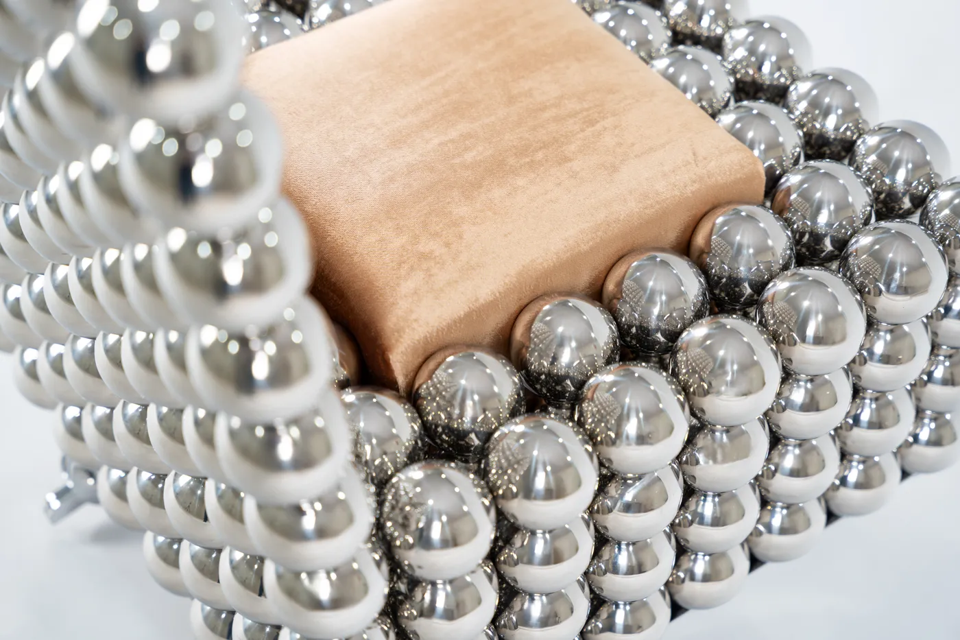 Detail of the rocking chair's wooden seat within the spheres