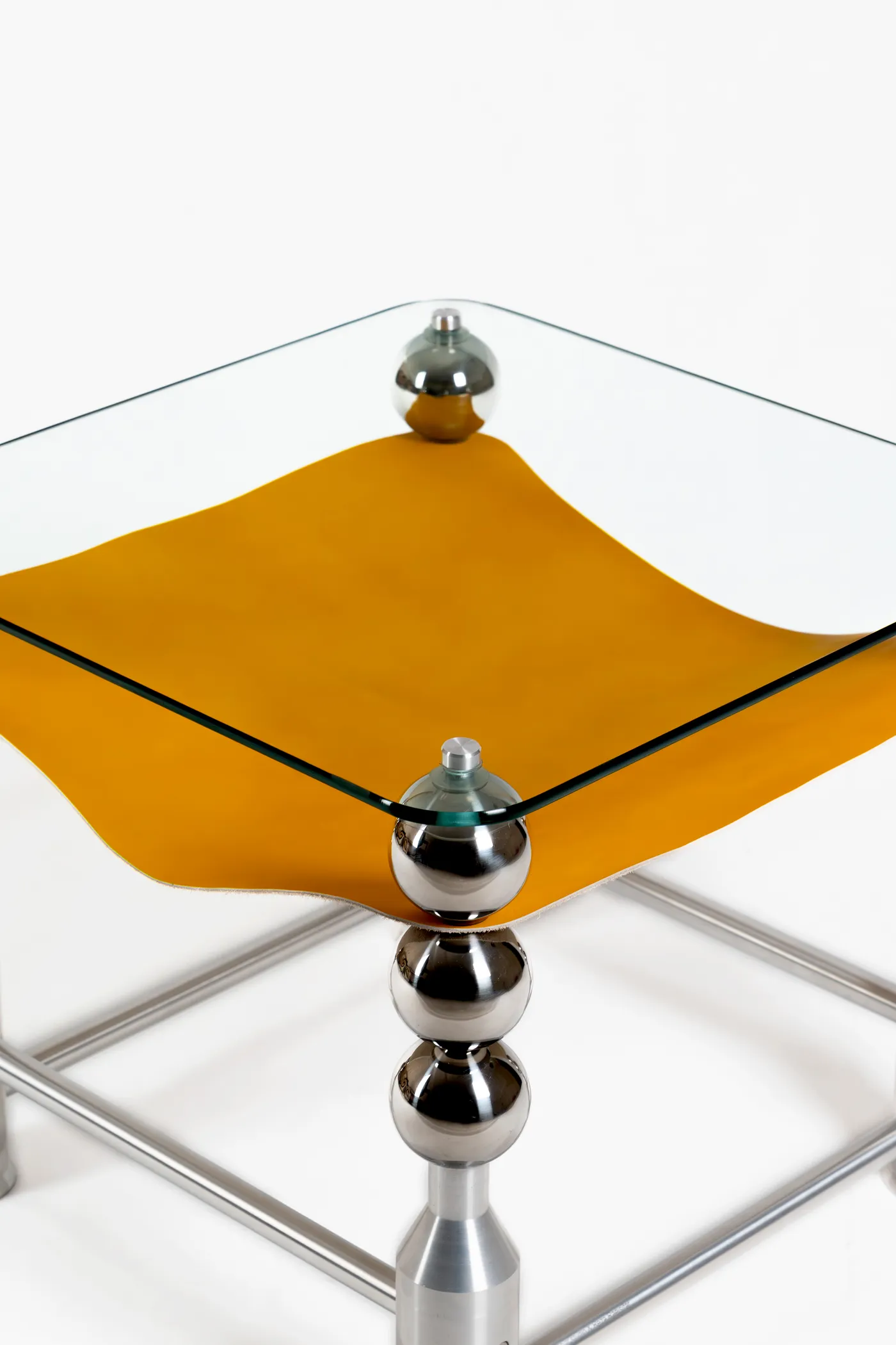 Wishes table with a leather-lined glass top on sphere columns