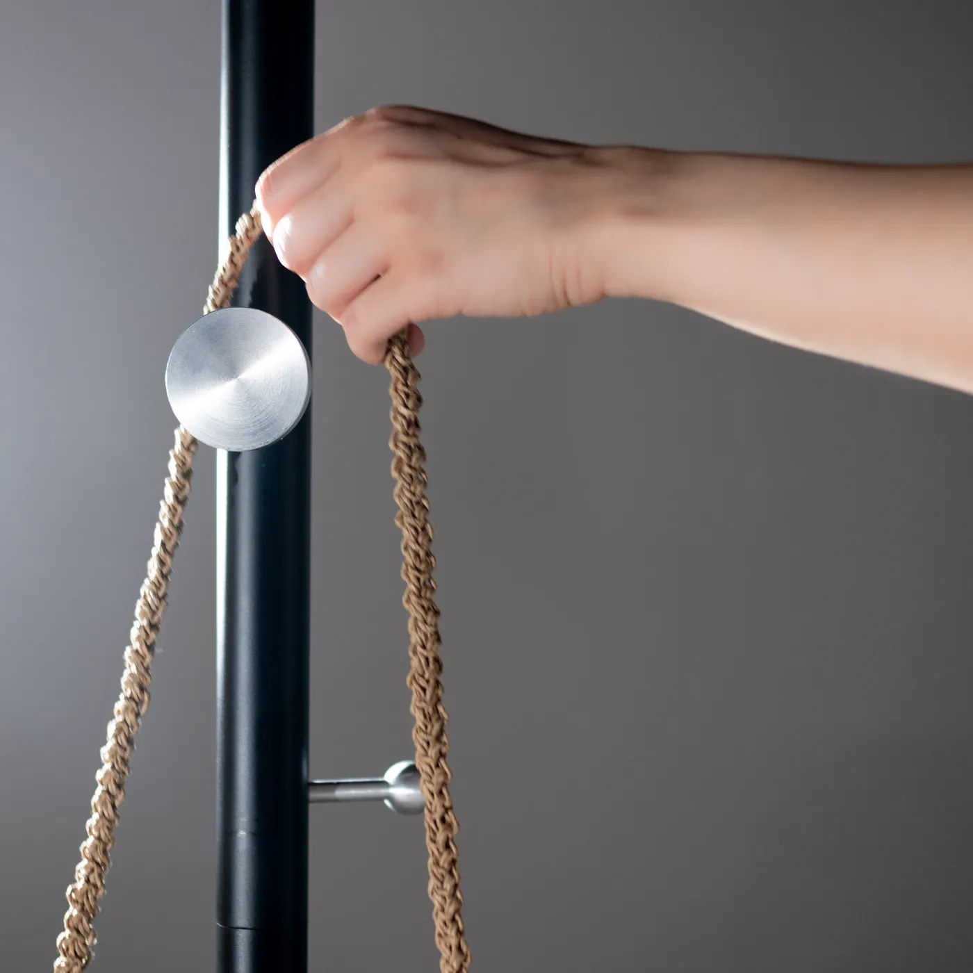 A hand looping a rope over the disc hook